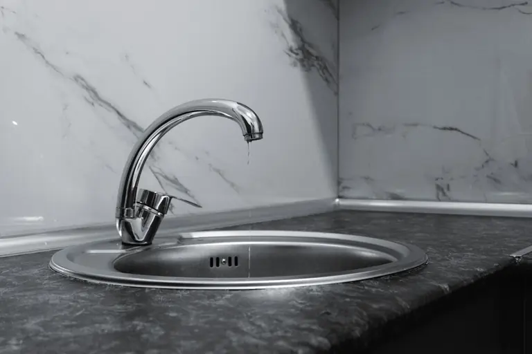 A clean and modern kitchen sink with a chrome faucet, highlighting minimalist design and water conservation.