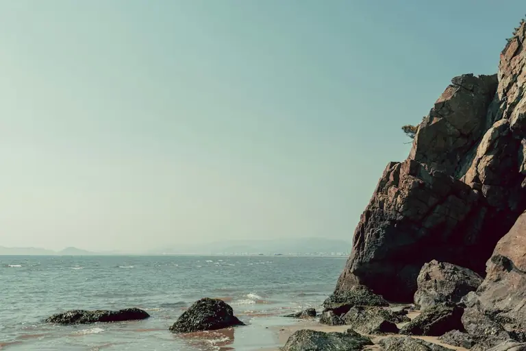 Rocky coastline with calm ocean under a clear sky