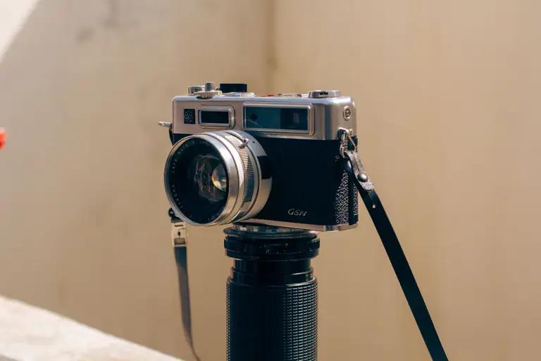 Close-up of a vintage film camera on a telephoto lens in natural daylight.
