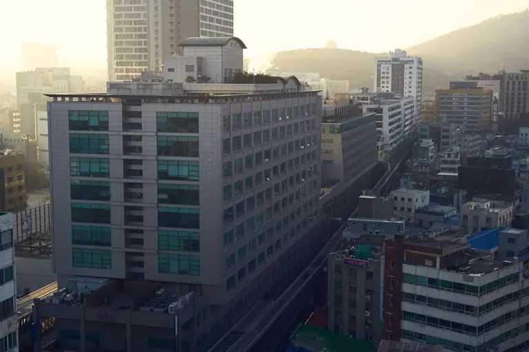 Aerial shot of a densely built urban area with modern architecture during sunset.