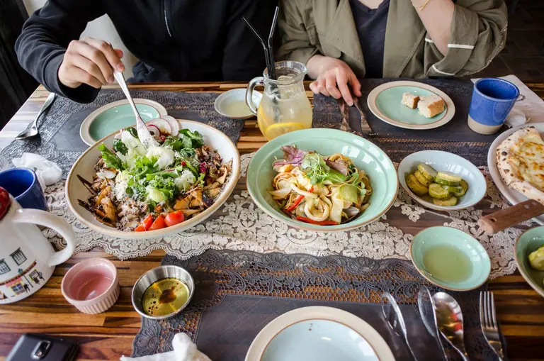 High-angle view of a vibrant meal with fresh salads, drinks, and diverse plating.