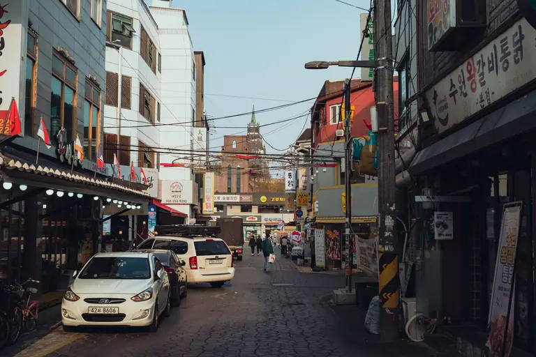 Vibrant street in Suwon-si, South Korea, showcasing local architecture and lifestyle.
