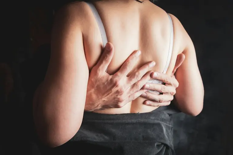 Hands embracing a woman's back