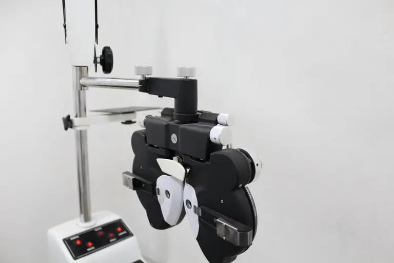 A phoropter used in optometry for eye examination in a bright medical office.