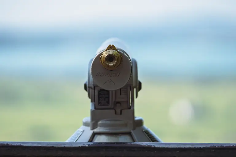 Close-up of a public telescope focusing on a scenic outdoor landscape, capturing a serene view.