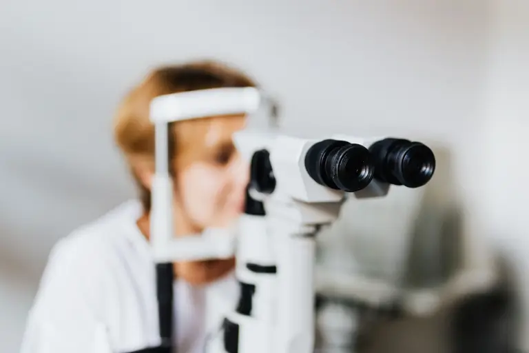 Close-up of an eye examination using a slit lamp machine in a clinical setting.