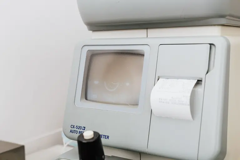 Close-up of optometry equipment showing printed receipt and display.