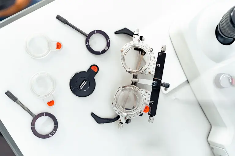 High-angle shot of optometry trial frames and lenses on a white surface.