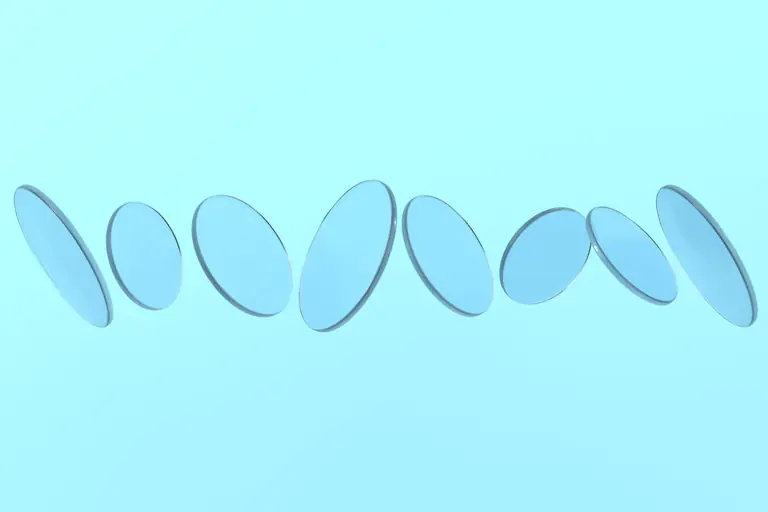 Abstract arrangement of transparent blue glass discs floating against a pastel blue backdrop.