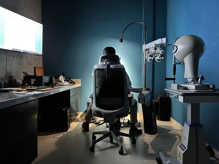 Back view of an eye care professional in a modern examination room in Los Mochis, Mexico.