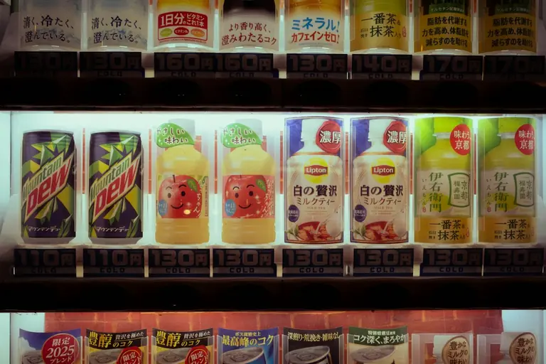 Drinks displayed in a brightly lit vending machine.