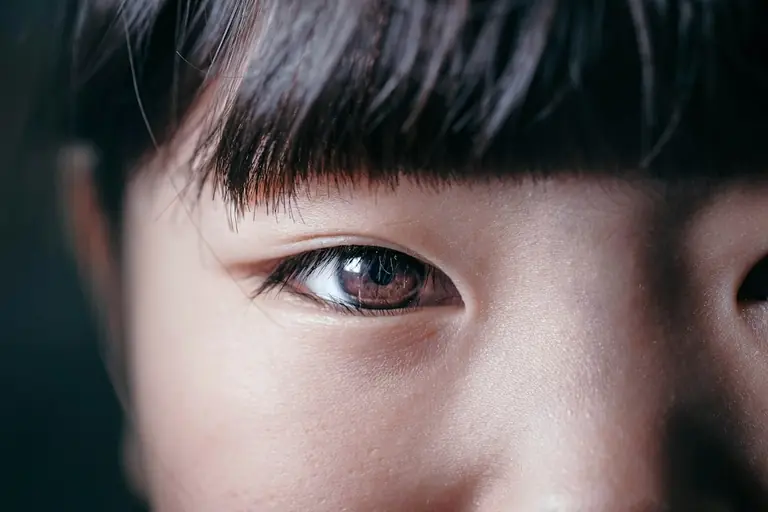 A close-up of an eye stares directly at the viewer