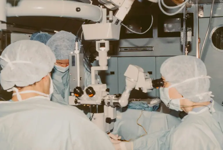 Surgeons operating with a microscope