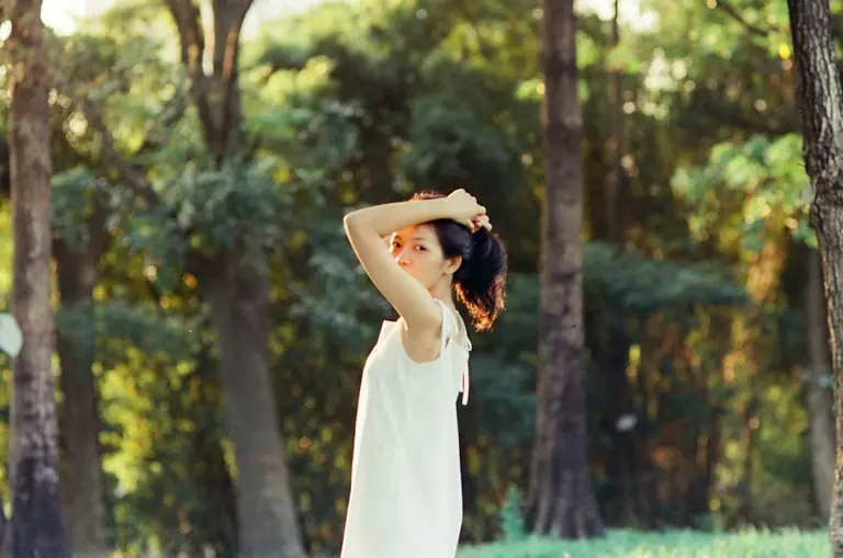 A woman in a white dress standing in a forest